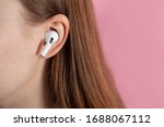 girl uses wireless white headphones on a pink background. Air Pods Pro. with Wireless Charging Case. New Airpods pro on pink background. Airpodspro. female headphones. apple headphones.EarPods