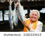 Small photo of Trad Province, Thailand, 12 June 2019 : a local villager showing her dry fish for sale. This village located by the sea shore at eastern of Thailand. Dry fish is good for local cooking recipe.
