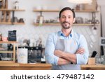 Own business. Successful cheerful small business owner standing with crossed arms