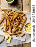 Small photo of Kohlrabi fries freshly roasted and served on rustic wooden table, low carb fries alternative with homemade mayonnaise sauce