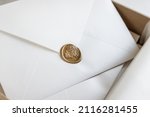 Blank white envelope sealed with golden wax stamp close up, copy space for stylish calligraphy and mail addressing