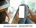 Close-up image of a woman in jeans relaxes sitting in the cafe and using her smartphone. smartphone white screen mockup for display your graphic banner.