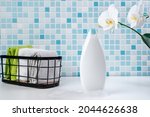 Shampoo on a white tile background. Shower gel with orchids in the bathroom. Cosmetics for skin health. Mockup for your logo. Bath mockup with copy space.  bottle of shampoo or shower gel