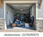 Small photo of Orlando, FL USA - March 3, 2022: An unorganized garage filled with a lot of stuff in a neighborhood.