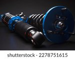 Small photo of auto suspension tuning coilovers shock absorbers and springs blue for a sports drift car on a dark background