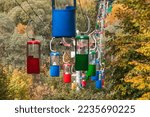 Colorful cableway cabins in autumn greenery in Kharkiv city recreation park