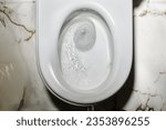 Small photo of Flushing toilets. Close up flushing water in toilet bowl. Toilet, flushing water. Selective focus. Top view
