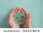 Small photo of Hands holding green happy smile face, good feedback rating,positive customer review, experience, satisfaction survey ,mental health assessment, child wellness,world mental health day, Compliment Day