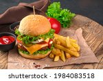 Homemade burger with beef, cheese and vegetables on a brown background. Fast food. Horizontal view, space for copying.