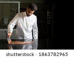 Small photo of Pastry chef working on tempering chocolate on marble table