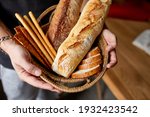 Close yp of man hand, holding basket with various bread freshly baked. Close up concept of homemade bread, small bakery, natural farm products, local food,  domestic production. Healthy and 