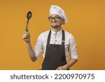 Small photo of the chef brandishes his spoon with a sly grin.