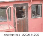 Small photo of Broken captain's wheelhouse on an old cargo ship with wooden door