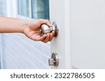 Hand opening Modern white door with chrome metal handle. Elements of interior, close up, To open the door, security, entrance concept.