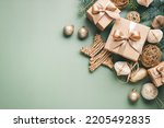 New Year card with Christmas gift boxes and golden decorations on khaki background.
