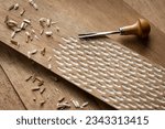 Small photo of Gouge tool on wood, woodcraft, carving a handmade texture on the surface surrounded by wood chips showing craftsmanship and slow living, vintage old technique, woodgrain