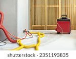 Small photo of Water damage restoration service in a leaking home with industrial air movers, dehumidifiers and pipes to remove the water and moist from the wet floor and repair the house. Household insurance