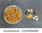 Small photo of Snack insects. Mealworm larvae as food and variation of nuts. Mealworms crustaceans tenebrio molitor, freeze-dried for snacking. Fried worms. Roasted mealworms. Animal snack concept