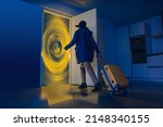The door is like a portal for travel. Portal to other dimensions. Surrealistic creative work about future travels. The man with the suitcase walks towards the gate in the doorway. Fast travel