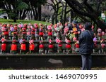 Small photo of TOKYO, JAPAN DECEMBER 29 2018: Elderly Japanese Couple Tending to Little Children Funeral Death Memorial Statues Representing & Commemorating Stillborn, Miscarried & Dead Infants at Zojoji Temple