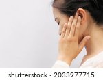Asian woman suffering from earache. Symptoms of acute external otitis media. Health care concept.