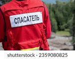 Small photo of Rescuer in Russia in a uniform with the inscription on the back Rescuer. A man in a red jacket is ready to help in trouble and save lives.