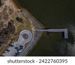 A high angle top down view of a wooden walking path and pier on Oyster Bay on Long Island, NY. Taken on a sunny day. The drone camera tilted downward.