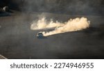 Small photo of Drifting car drifting with billowing smoke trails golden sunrise fast cars