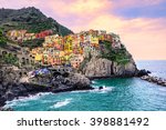 Colorful traditional houses on a rock over Mediterranean sea on dramatic sunset, Manarola, Cinque Terre, Italy