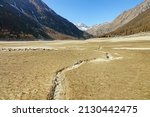 Small photo of Climate change. Large mountain lake completely drained by drought. Ceresole Reale, Italy - February 2022