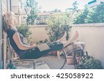 lazy - relaxed blond woman reading, falling asleep in balcony on a warm summer day - custom vintage colors fading and haze effects 