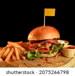 Small photo of fresh tasty burger on black background with flag sewn on it