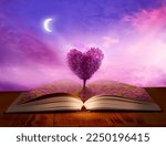 Open magic book  of life, knowledge, wisdom.  Fantasy, nature or learning concept with  heart shaped tree 