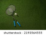 Badminton racket and shuttlecock on green grass background.