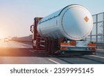 Small photo of Petrol cargo truck driving on highway hauling oil products. Fuel delivery transportation and logistics concept on a sunny summer evening. Compressed gas carrier truck rear view on a highway.