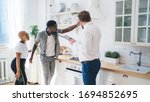 Small photo of Side view of professional bearded chubby man in formal outfit with clipboard inspecting hood fan together with considerate ethnic couple while standing at modern sunny apartment