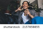 Small photo of Happy Asian female in smart casual jacket enjoying coffee break for calling and talking via smartphone technology, cheerful woman with takeaway caffeine beverage phoning via mobile application