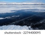 Beautiful scenery of frozen lake Torneträsk (Tornestrask) around Abisko National Park (Abisko nationalpark). Deep cracks in the ice sheet.  Sweden, Arctic Circle, Swedish Lapland