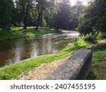Small photo of VILNIUS, LITHUANIA - JULY 30 2013: Vilnia River, in Old Town. Bernadine Park is on the opposite bank.
