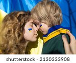faces of boy child and young woman with painted yellow - blue heart on cheeks. Family, unity, support. Ukrainians are against war. request for help to world community.Caring for each other