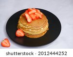 Pancakes with strawberries on a blurred background. Food photography.