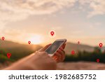 Man hand using smart phone on top of mountain with navigator location point abstract background. Technology business and travel adventure concept. Vintage tone filter effect color style.
