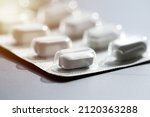 Small photo of Closeup of pills in blister pack. Headache pills, painkillers, antibiotics or antidepressants tablets