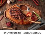 Small photo of Top view on grilled beef tomahawk steak with pepper sauce