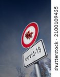 Small photo of Model of corona virus as symbol for the new covid-19 mutant virus from south africa on a german traffic sign