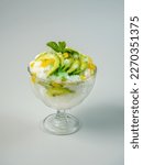Small photo of Avocado coconut jackfruit ice cocktail on grey background, also known as "Es Teler" in Indonesia.