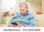 Small photo of Portrait of a grandmother 90 years old, longevity, an elderly woman holds a smartphone in her hands and communicates online, modern communications and longevity, anti-aging, loneliness.
