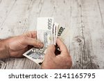 Czech banknotes in a fan in the hands of a trader. Financial concept.Financial concept in Czech currency. business, finance, saving and cash concept - close up of euro paper money and coins on table