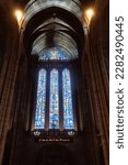 Small photo of Liverpool, United Kingdom -2023: Liverpool Cathedral's west window with Benedicite window by Carl Johannes Edwards. For You pink neon sign by Tracey Emin reads "I felt you and I knew you loved me"