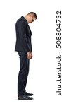 Small photo of Businessman stands in profile hanging his head , isolated on a white background. Difficulties at work. Problems and issues. Predicament. Necessity to decide. Confusion and doubt.